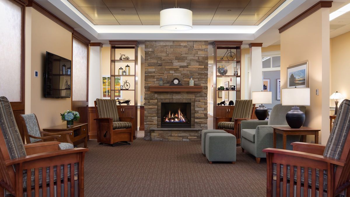 A cozy and modern living room with a stone fireplace and comfortable seating.
