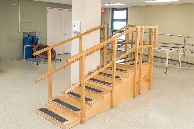 A set of stairs used for physical rehabilitation exercises in an indoor setting.