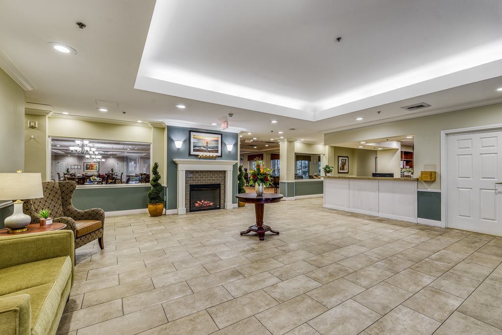 A spacious hotel lobby with a fireplace, reception desk, and elegant furnishings.
