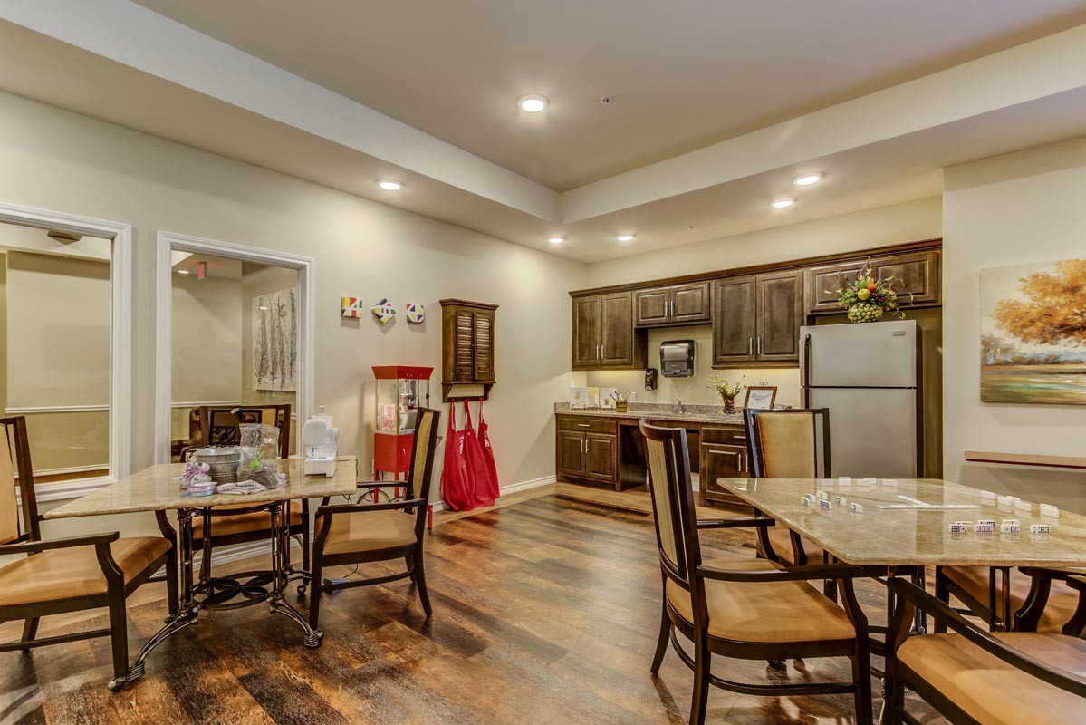 A modern kitchen and dining area with wood flooring, featuring sleek cabinetry and elegant furniture.