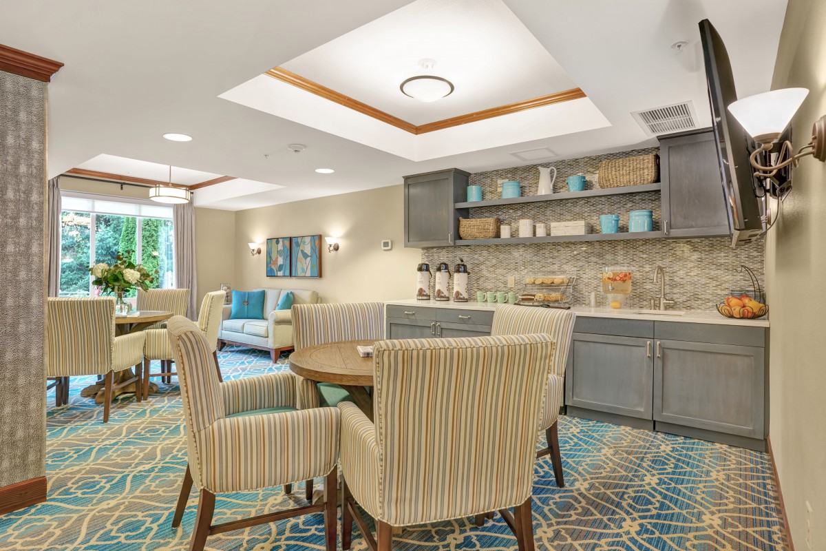 A modern living area with comfortable seating and a kitchenette.