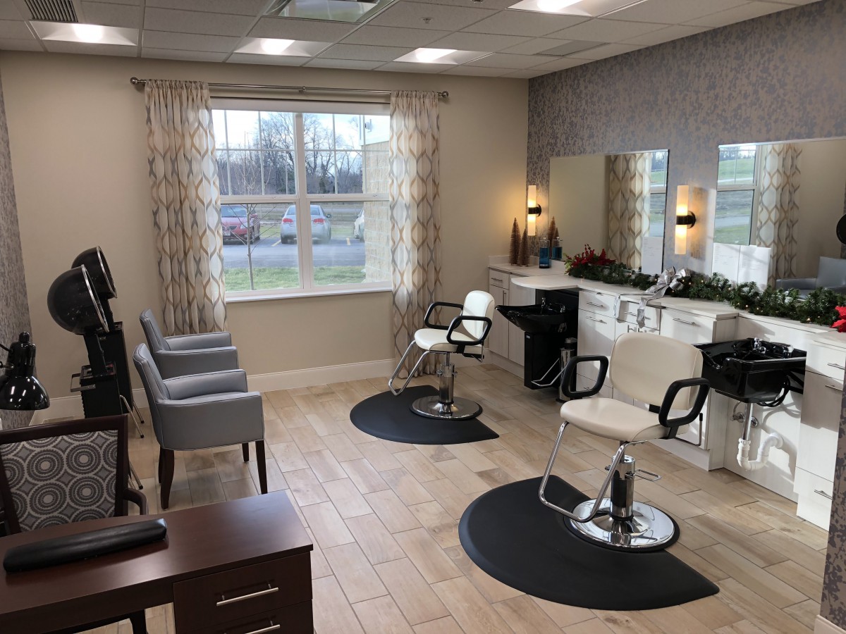A well-lit hair salon with styling chairs and mirrors, featuring comfortable seating and modern decor.