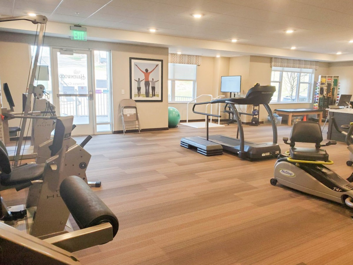 A spacious gym with modern exercise equipment including treadmills and stationary bikes.