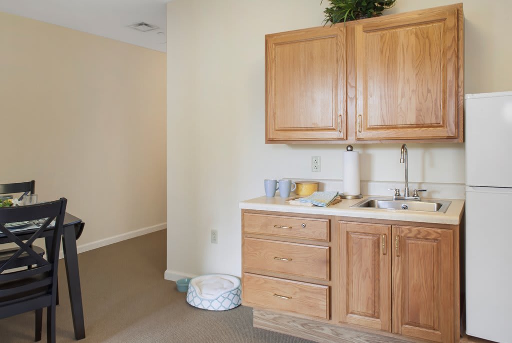 A small kitchen area with wooden cabinets, a sink, and countertop essentials.