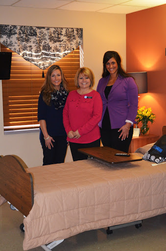 Three women gather in a warmly decorated room for a collaborative meeting.