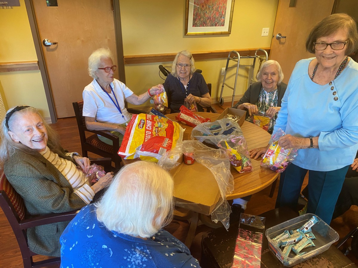 A group of seniors engaging in a community activity around a table.