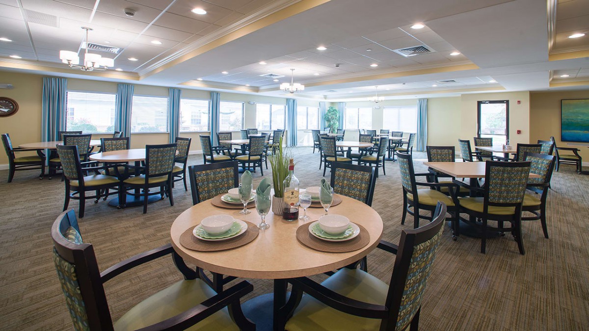 A spacious dining room with elegantly set tables and chairs.