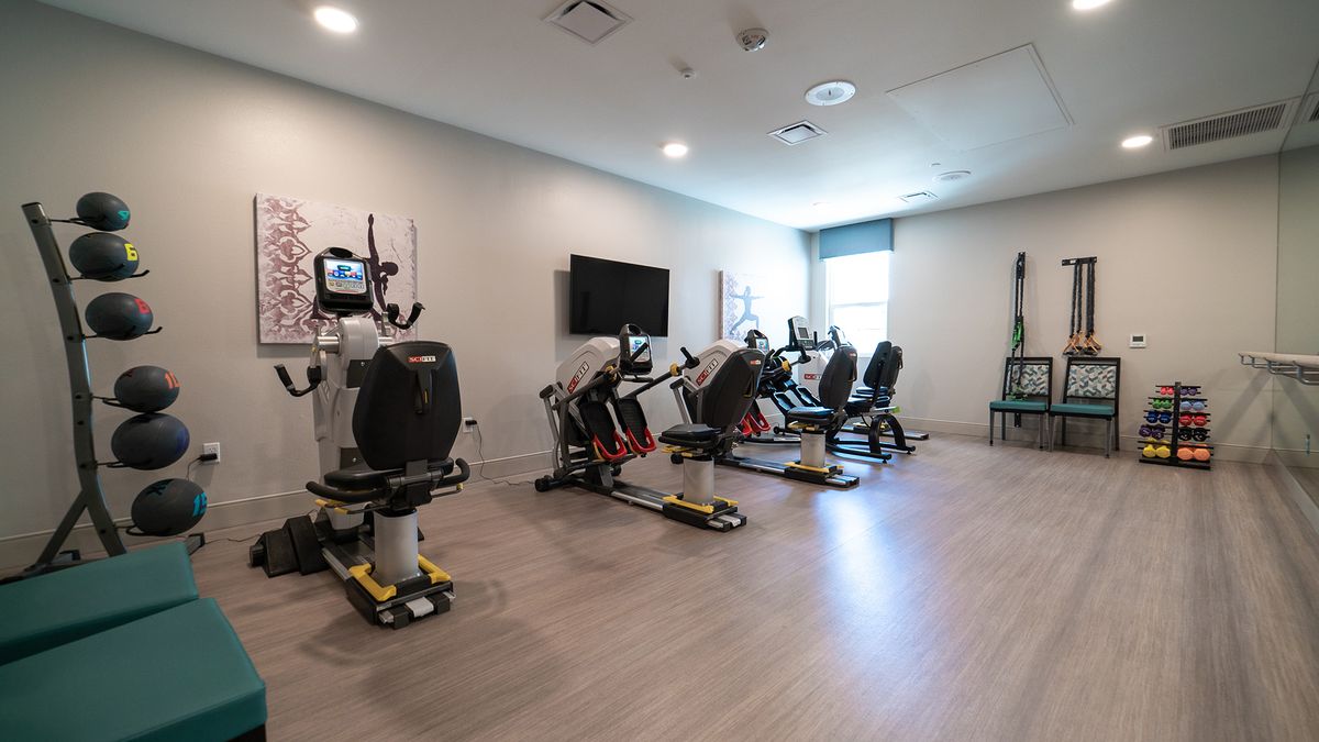 A modern gym room with exercise equipment lined up for use.