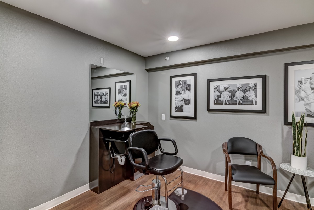 A modern salon interior with stylish chairs and framed artwork on the walls.