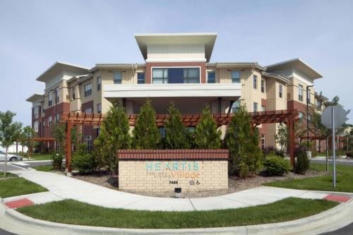 A modern apartment complex with landscaped greenery and a welcoming entrance.