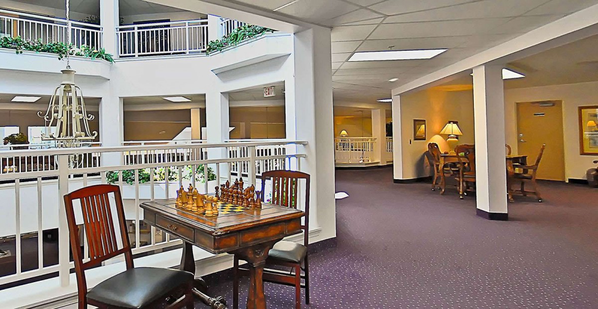 A cozy hotel lobby featuring a chess table and seating area.