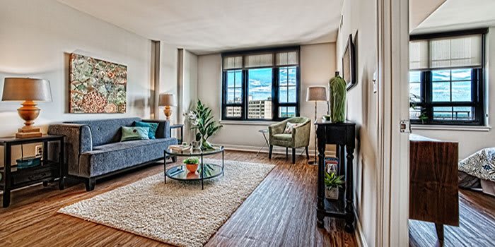 A modern living room with stylish decor and a large window.