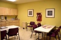 A breakroom with tables, chairs, and kitchen facilities.