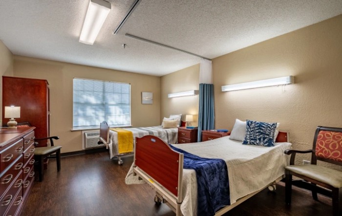 Hospital room interior with two patient beds and medical equipment.