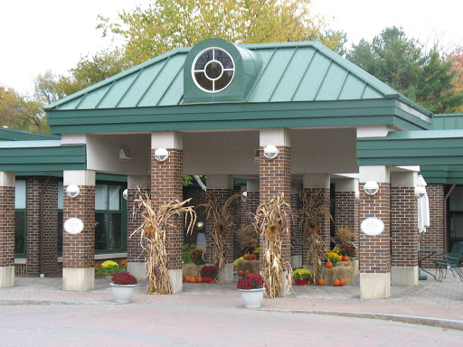 A charming entrance adorned with autumn decorations, featuring corn stalks and vibrant flowers.