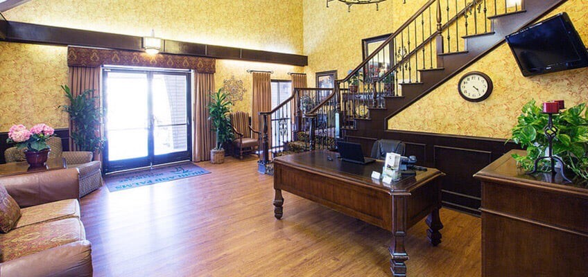 A hotel lobby featuring a wooden staircase and reception desk.