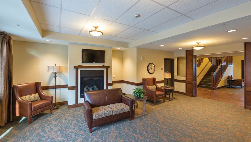 A cozy lobby area featuring comfortable seating, a fireplace, and a wall-mounted television.