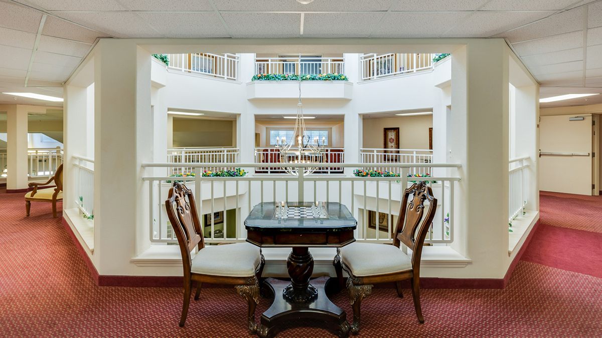 A classic-style indoor seating area with a small table and two chairs overlooking a balcony.