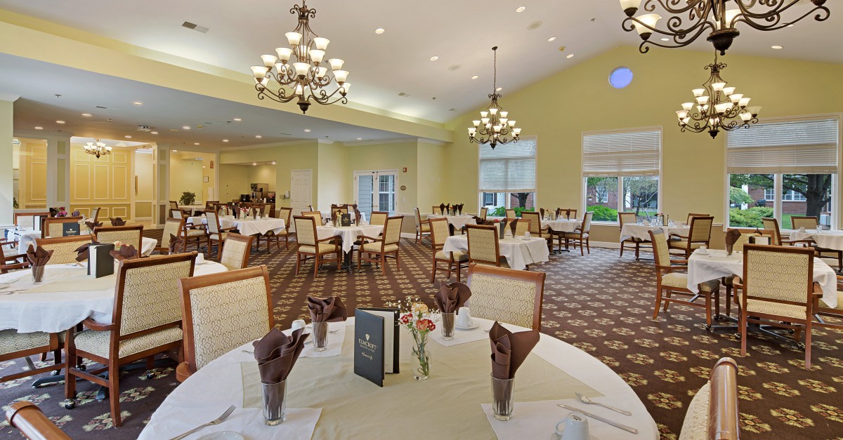 Elegant dining room with neatly arranged tables and chandeliers.
