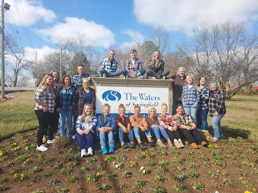 A joyful gathering of friends and community members at The Village, celebrating together under a beautiful blue sky.