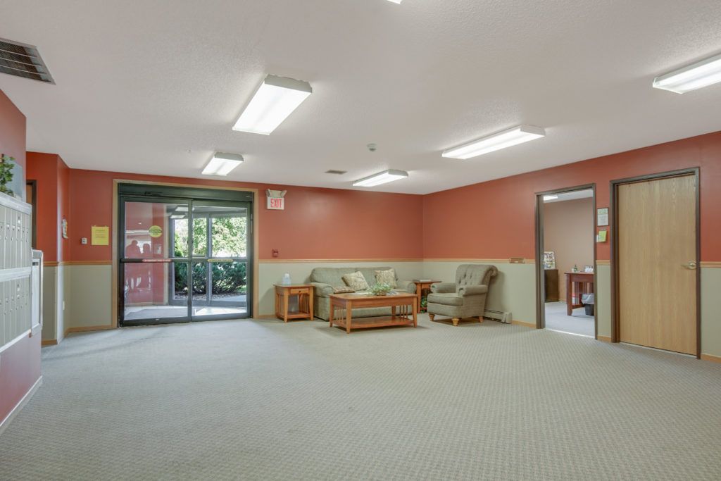A spacious room with comfortable seating and large windows.