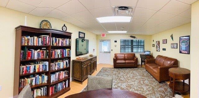 A cozy living room with a bookshelf, sofas, and a television.