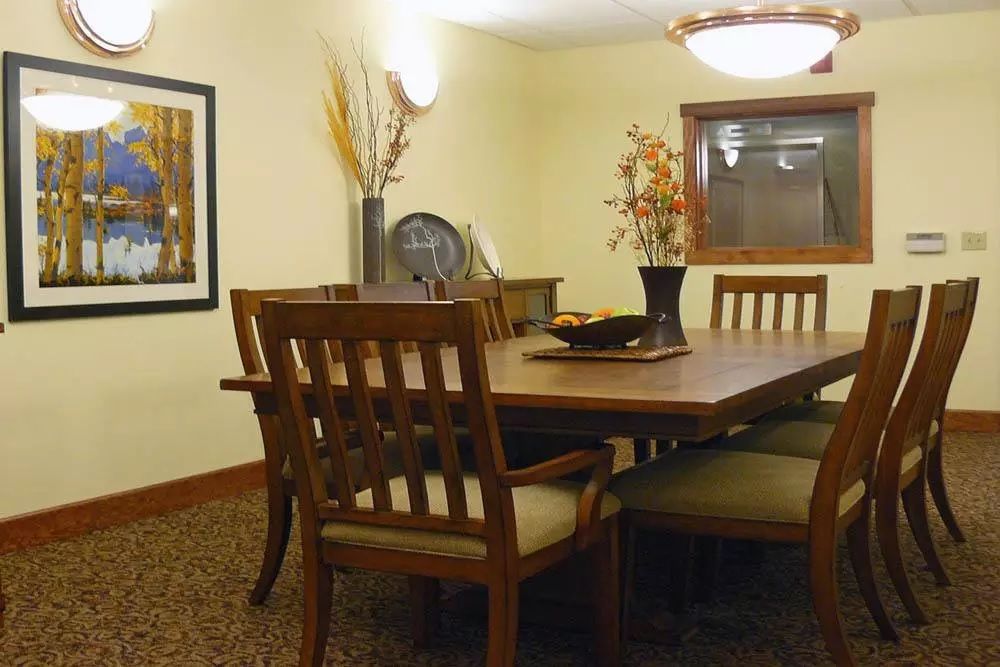 A cozy dining room with a wooden table and chairs, adorned with elegant decor and soft lighting.