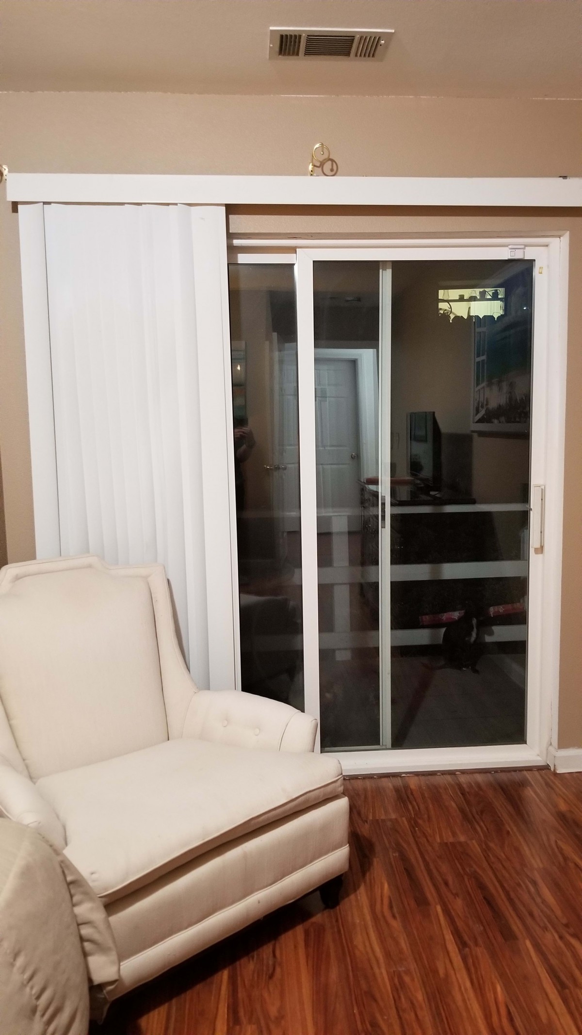 A cozy living room with a sliding glass door and a comfortable chair.