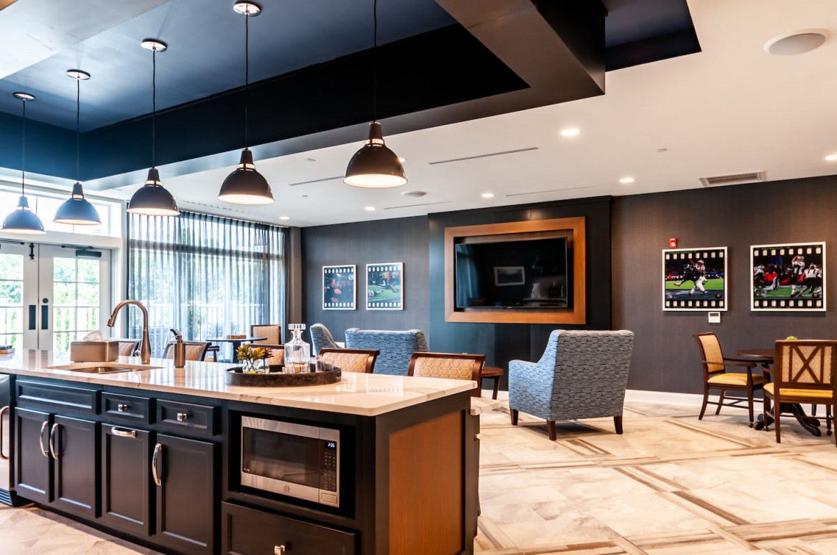 Modern open kitchen and living area with stylish lighting and furniture.