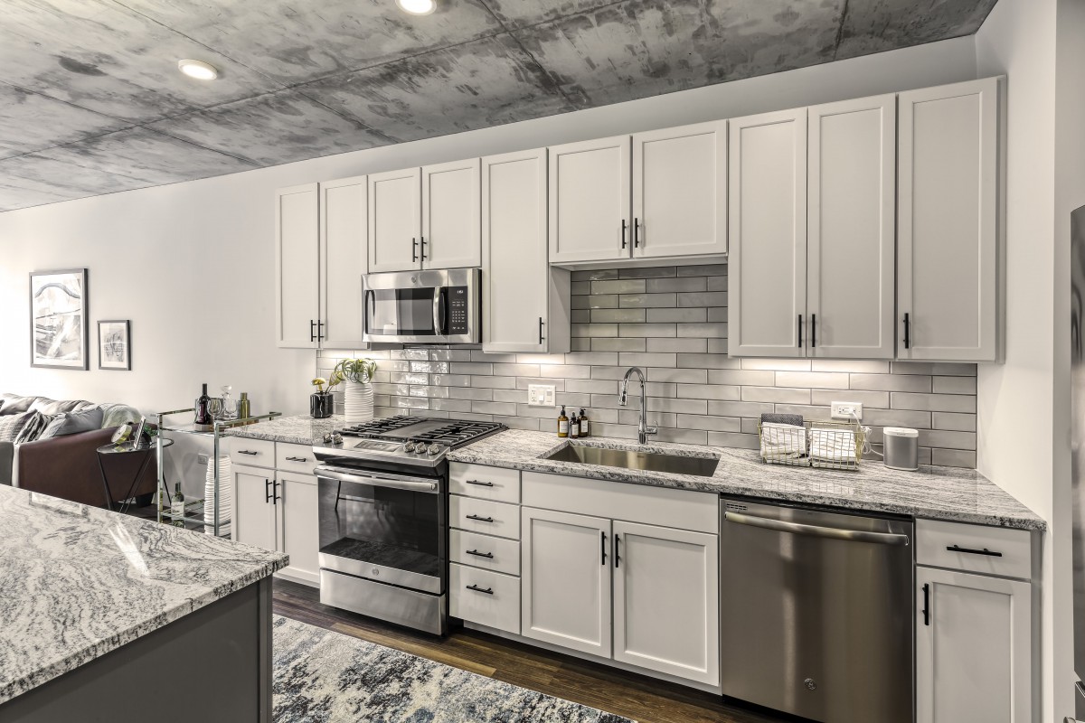 A modern kitchen featuring white cabinets, stainless steel appliances, and a subway tile backsplash.
