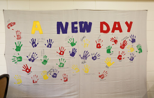 A vibrant expression of unity and creativity, showcasing handprints and the message 'A NEW DAY'.