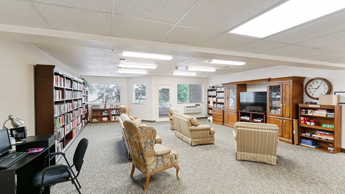 A cozy living room with bookshelves, comfortable seating, and a television.