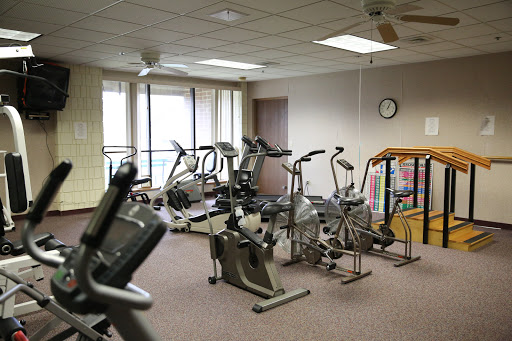 A well-equipped gym with various exercise machines and a bright, welcoming atmosphere.