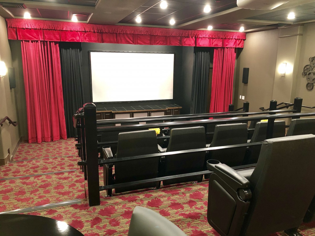 A cozy home theater setup with red curtains and comfortable seating.