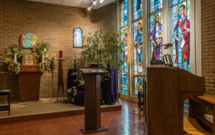 A serene chapel interior with stained glass windows and a wooden pulpit.