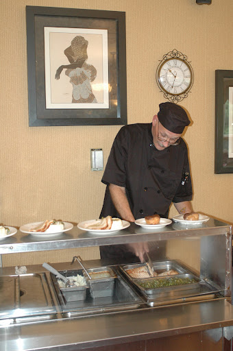 A chef meticulously preparing plates of food in a restaurant setting.