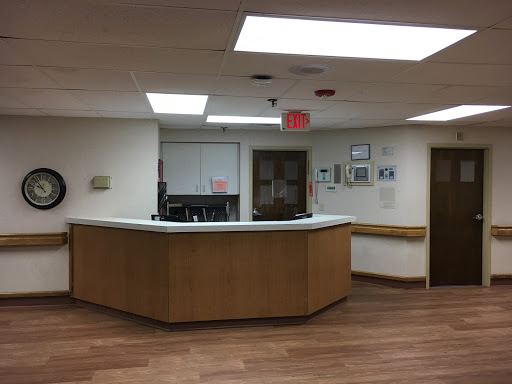 A view of the reception area in a medical facility, featuring a wooden front desk and a cozy ambiance.