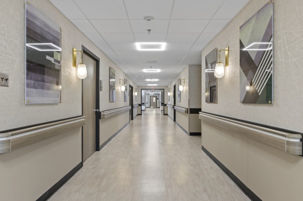 A well-lit hospital corridor with doors on both sides.