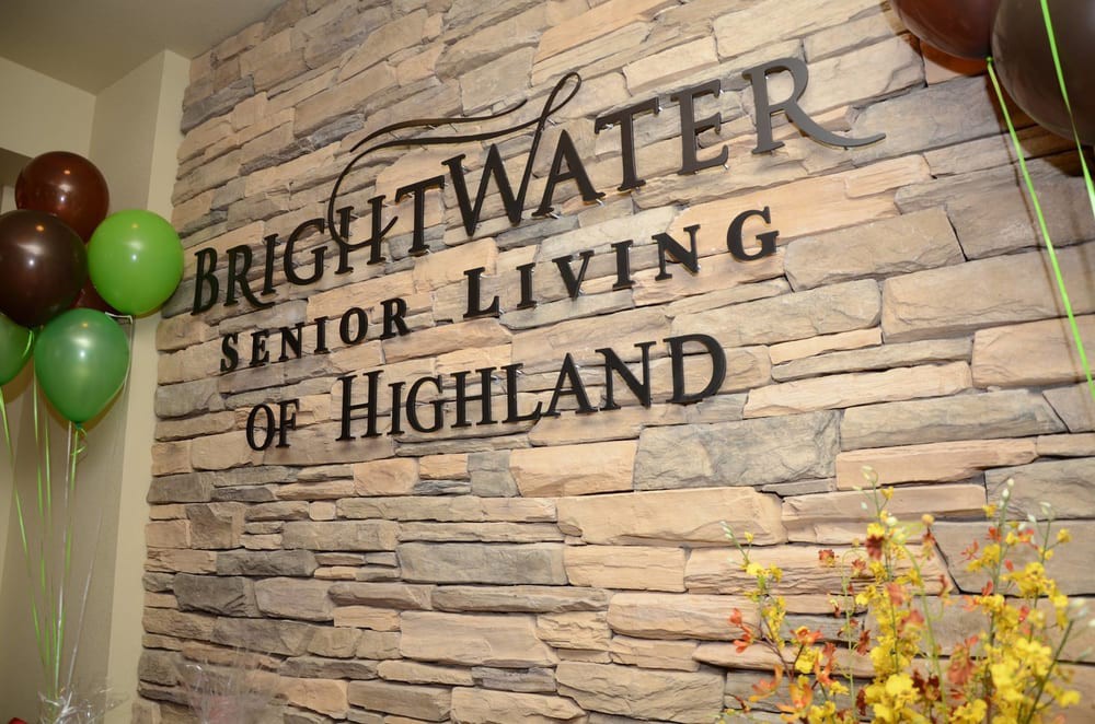 Sign for BrightWater Senior Living of Highland on a brick wall.