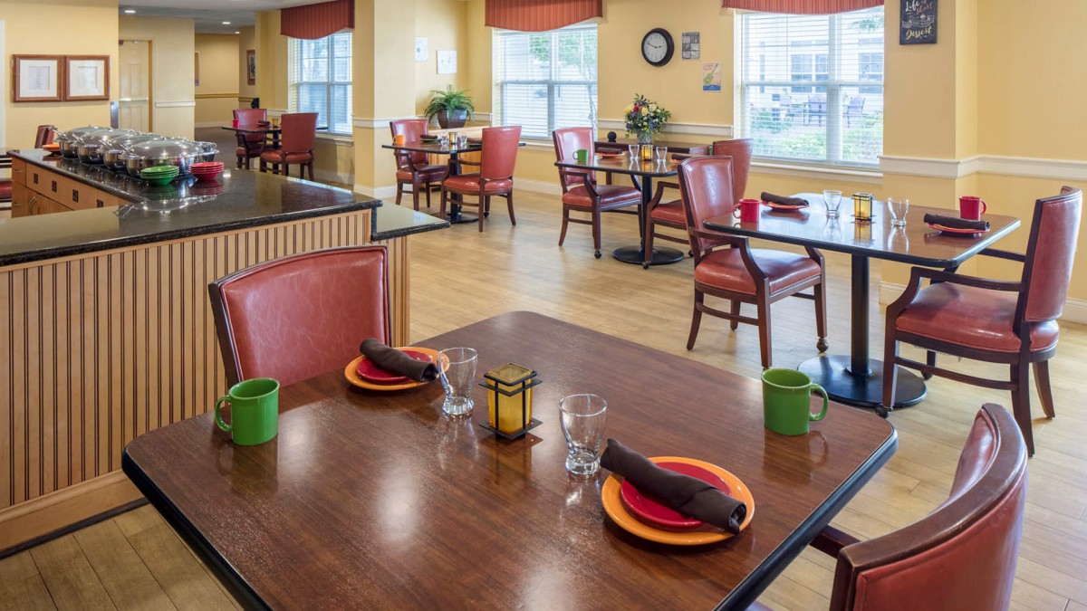 A cozy dining area with neatly set tables and comfortable seating.
