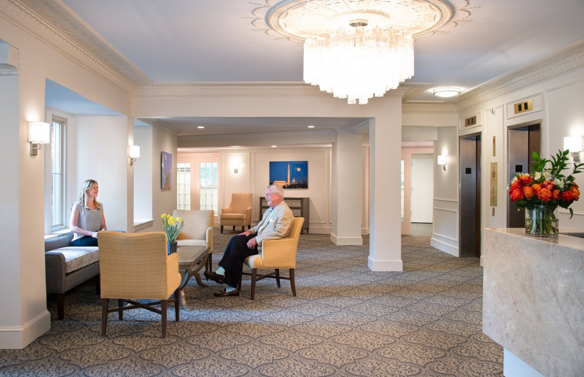 A spacious lobby with comfortable seating and a grand chandelier.