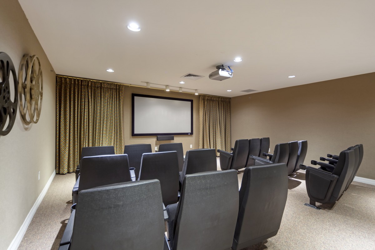 A conference room with rows of chairs facing a projector screen.