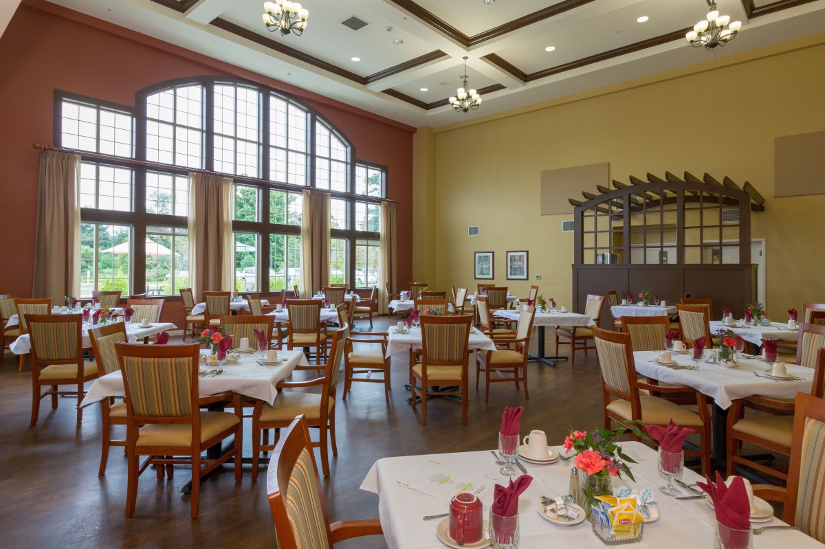 A well-lit dining area with multiple tables and chairs arranged neatly.