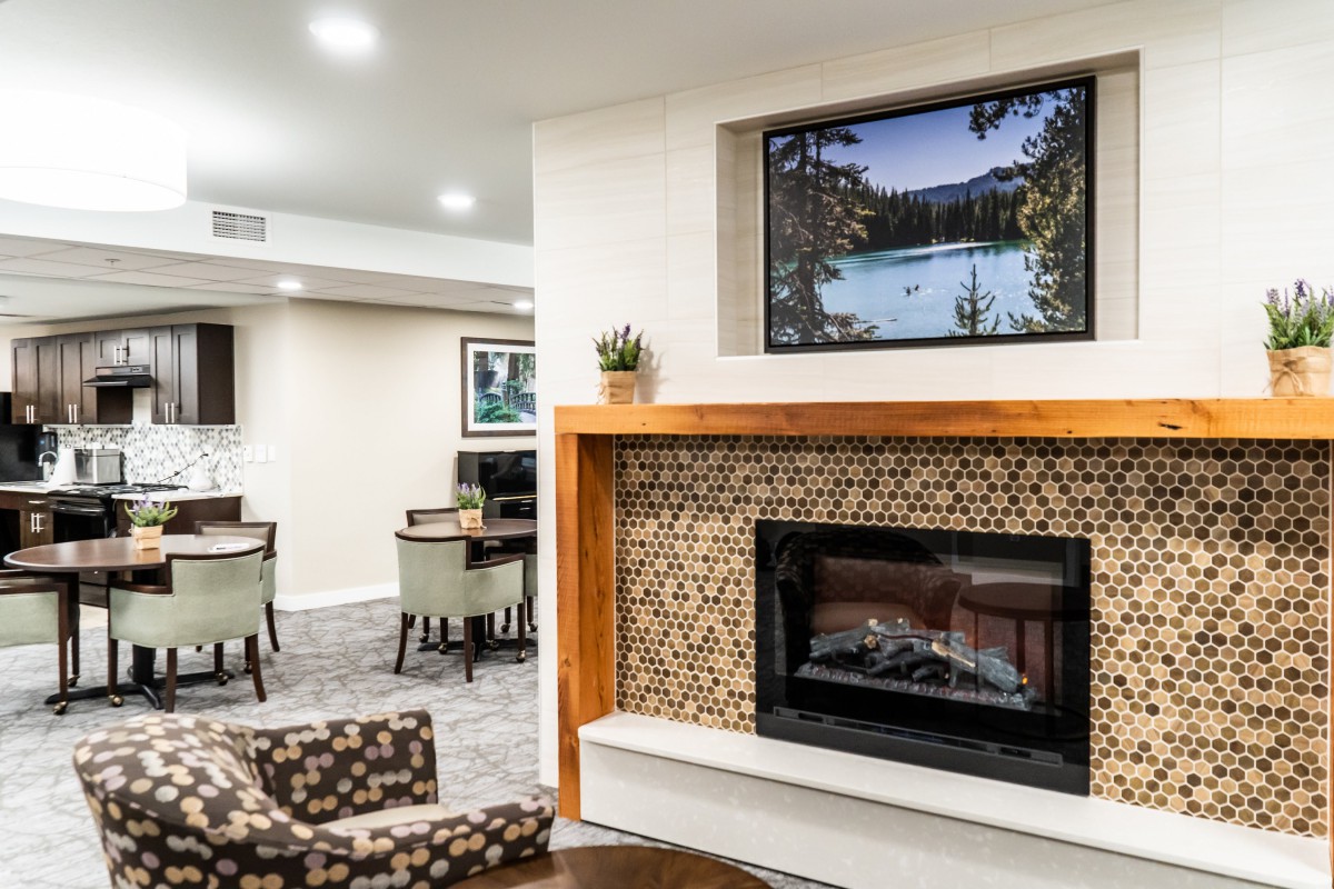 A cozy living room with a fireplace, seating area, and decorative artwork.