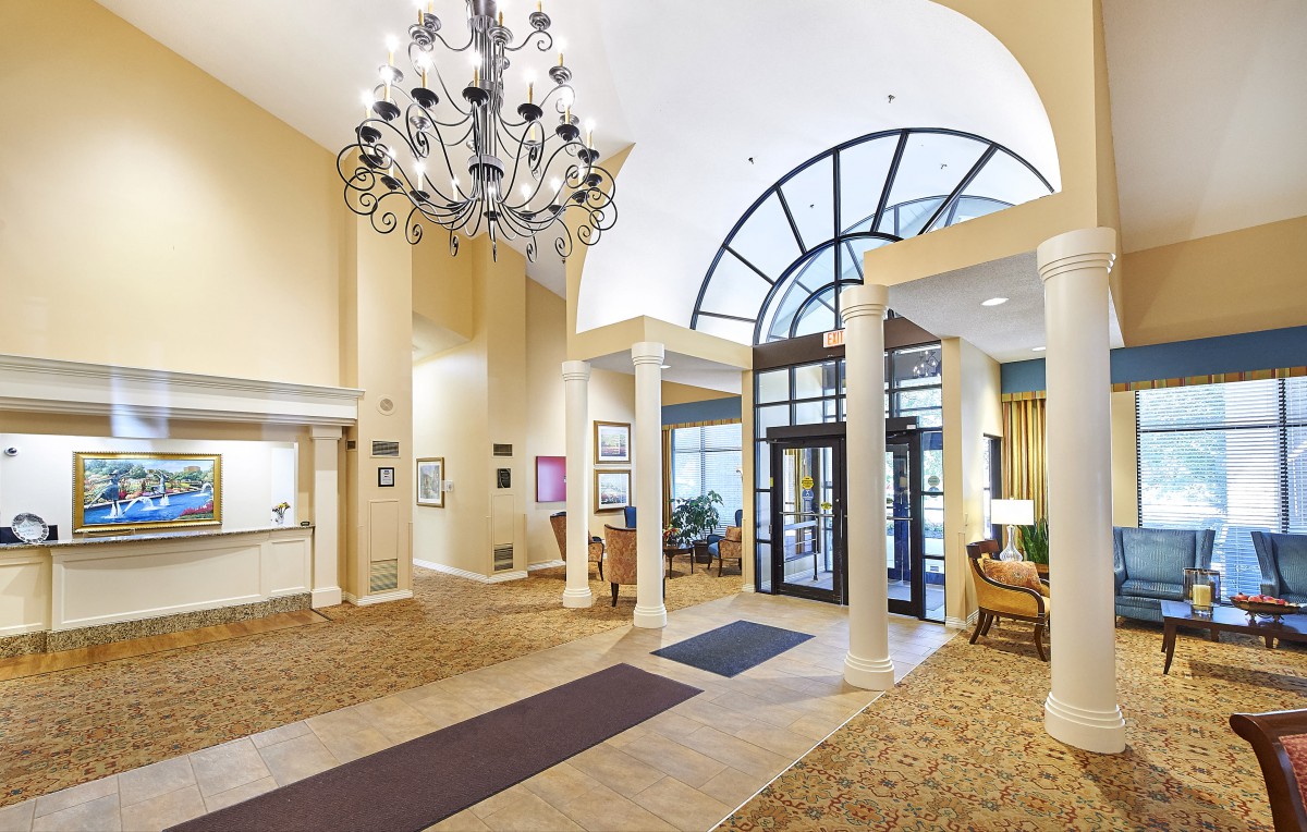 A spacious and elegant lobby with a grand chandelier, large windows, and comfortable seating areas.