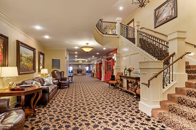A spacious hotel lobby featuring elegant furniture and a grand staircase.