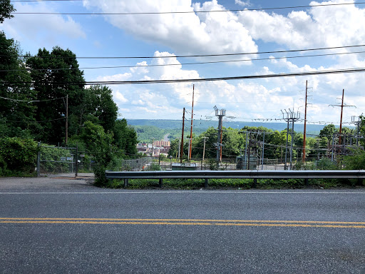 A scenic view showcasing a road lined with greenery under a cloudy sky.