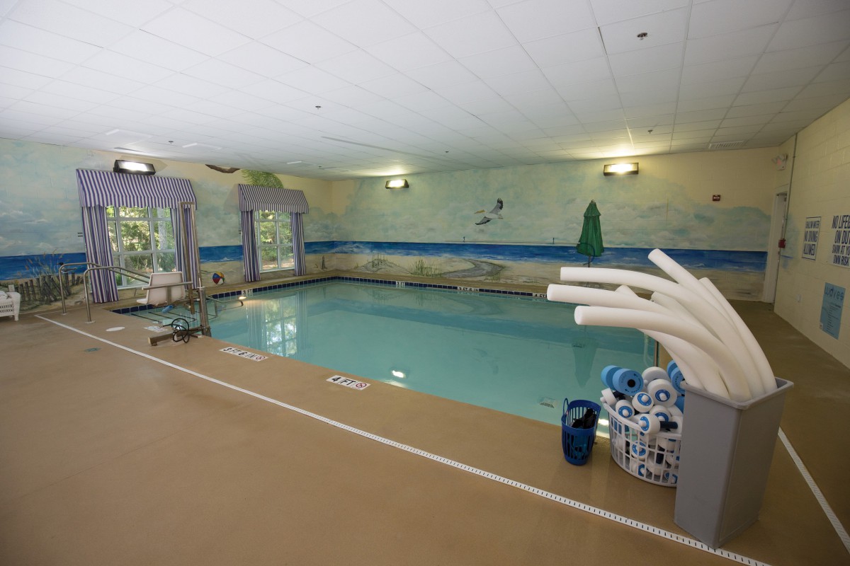 An indoor swimming pool equipped with floatation devices and pool amenities.