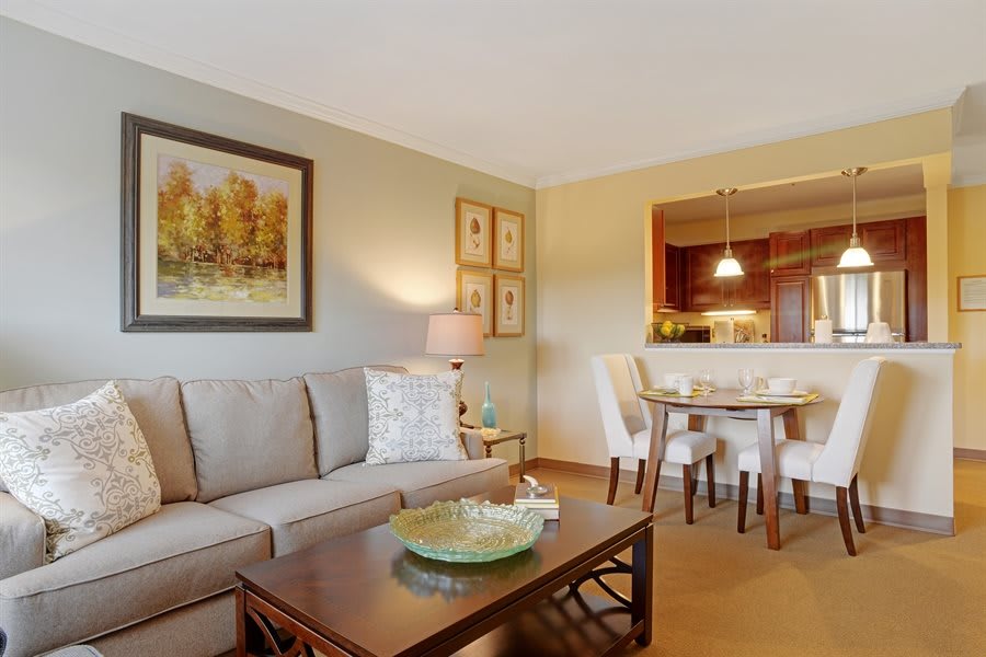 A cozy living room with a sofa, coffee table, and adjoining dining area.