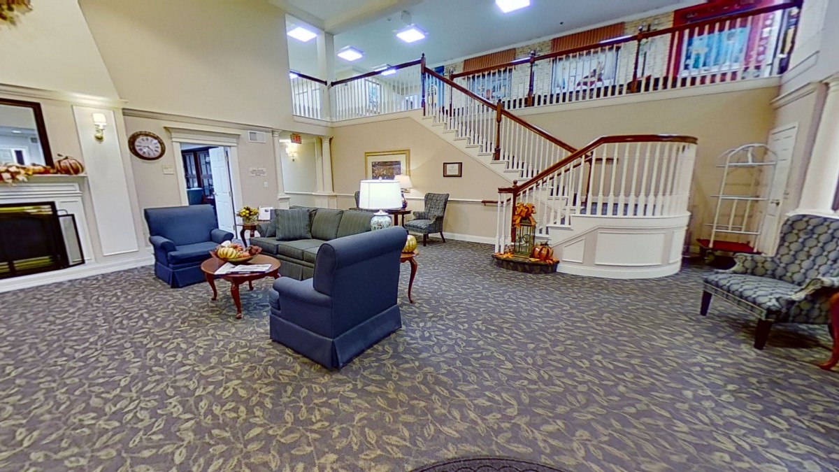 A spacious lobby with comfortable seating and elegant stairs.